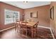 Cozy dining room features wood table and chairs, brown walls and natural light from a window at 10508 Madison Park Dr, Charlotte, NC 28269