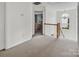 Upstairs hallway with carpet, wooden railing and a bedroom view at 10508 Madison Park Dr, Charlotte, NC 28269