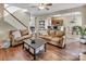 Bright living room with wood floors, staircase, and a view of the kitchen at 10508 Madison Park Dr, Charlotte, NC 28269