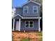 Two-story home features gray siding, white trim, covered porch and a well-lit, eye-catching, exterior elevation at 115 Allen St, Rock Hill, SC 29730