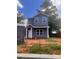 Two-story home features gray siding, white trim, covered porch and a well-lit, eye-catching, exterior elevation at 115 Allen St, Rock Hill, SC 29730