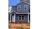 Two-story home features gray siding, white trim, covered porch and a well-lit, eye-catching, exterior elevation at 115 Allen St, Rock Hill, SC 29730