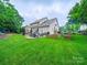 Expansive backyard featuring a lush lawn, a patio seating area, and mature trees for shade and privacy at 1151 Gower St, Fort Mill, SC 29708