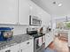 Well-lit kitchen featuring stainless appliances, granite counters, subway tile backsplash, and wood floors at 1151 Gower St, Fort Mill, SC 29708