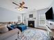 Cozy living room featuring a fireplace, plush sectional sofa, and a ceiling fan for added comfort at 1151 Gower St, Fort Mill, SC 29708