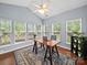 Bright sunroom with many windows, hardwood floors, a ceiling fan, and a desk with greenery at 1151 Gower St, Fort Mill, SC 29708