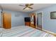 Cozy bedroom with hardwood floors, a ceiling fan, TV and view of a bathroom through an open door at 1239 Christopher Cir, Rock Hill, SC 29730