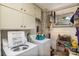 Bright laundry room with white cabinets, washer, dryer and a convenient clothes-hanging rack by the window at 1239 Christopher Cir, Rock Hill, SC 29730