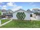 Well-maintained backyard features lush grass, a detached garage with climbing vines, and a patio set at 13624 Jacks Ln, Pineville, NC 28134
