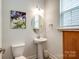 Bathroom featuring a pedestal sink and window, with clean white and gray finishes at 13624 Jacks Ln, Pineville, NC 28134