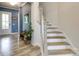 Entryway with beautiful wood-look floors, staircase, bench, and a stylish front door at 13624 Jacks Ln, Pineville, NC 28134