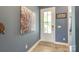 Bright foyer featuring wood-look floors, decorative artwork, and a paneled front door at 13624 Jacks Ln, Pineville, NC 28134