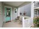 Inviting front porch with a brightly colored door, hanging planters, and comfortable rocking chairs at 13624 Jacks Ln, Pineville, NC 28134