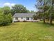 Spacious backyard view featuring home exterior and green lawn at 1401 Thompson Ave, Charlotte, NC 28216