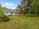 Large grassy backyard featuring the home's exterior and mature trees at 1401 Thompson Ave, Charlotte, NC 28216