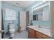 Bright bathroom featuring blue walls, wood vanity, and decorative mirror at 1401 Thompson Ave, Charlotte, NC 28216