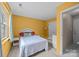 Cozy bedroom with yellow walls, double bed, window and neutral carpet at 1401 Thompson Ave, Charlotte, NC 28216