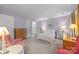 Comfortable bedroom featuring light purple walls, lamps, and warm natural light at 1401 Thompson Ave, Charlotte, NC 28216