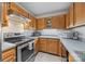 Well-lit kitchen features stainless steel appliances, wood cabinetry, and tile backsplash at 1401 Thompson Ave, Charlotte, NC 28216