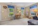 Comfortable living room with large windows, neutral walls and carpet, with wooden furnishings at 1401 Thompson Ave, Charlotte, NC 28216