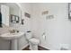Charming powder room with a pedestal sink, decorative mirror, and modern fixtures at 145 Marron Dr, Indian Trail, NC 28079