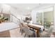 Dining room with wood table, neutral chairs, staircase, and sliding glass door to an outdoor space at 145 Marron Dr, Indian Trail, NC 28079
