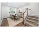 Inviting dining area with modern table setting, large window, and elegant stairway access to the second floor at 145 Marron Dr, Indian Trail, NC 28079