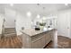 Kitchen island with granite countertop and pendant lights overlooking open layout to living area and stairs at 145 Marron Dr, Indian Trail, NC 28079