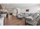 Open living space with a comfortable sectional couch, hardwood floors, and a view to the kitchen at 145 Marron Dr, Indian Trail, NC 28079