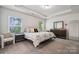 Spacious main bedroom featuring tray ceilings, two windows, carpet flooring, and an ensuite bathroom at 145 Marron Dr, Indian Trail, NC 28079