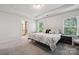 Bright and airy main bedroom featuring tray ceilings, large windows, and carpet flooring at 145 Marron Dr, Indian Trail, NC 28079