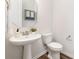 Neat powder room featuring a pedestal sink, modern fixtures, and a decorative mirror for added charm at 145 Marron Dr, Indian Trail, NC 28079