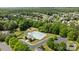 Community pool and clubhouse, with mature trees, playground, and parking area at 16117 Wrights Ferry Rd, Charlotte, NC 28278