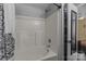 A clean bathroom featuring a tub with white tile and a shower head at 16117 Wrights Ferry Rd, Charlotte, NC 28278