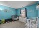 Bright Bedroom with two cribs and blue walls with mounted decor at 16117 Wrights Ferry Rd, Charlotte, NC 28278