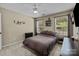 This is a cozy bedroom with a ceiling fan, a neutral color scheme, and two windows for natural light at 16117 Wrights Ferry Rd, Charlotte, NC 28278