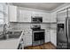 A modern kitchen with white cabinets, stainless steel appliances, and a stylish subway tile backsplash at 16117 Wrights Ferry Rd, Charlotte, NC 28278