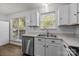 Bright kitchen with white cabinets, stainless steel appliances, and a view of the backyard through the windows at 16117 Wrights Ferry Rd, Charlotte, NC 28278