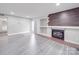 Open living room showcasing wood accent wall fireplace and modern grey flooring at 1847 J Julian Ln # A, Charlotte, NC 28208