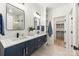Modern bathroom featuring double sinks, walk-in shower, and access to a walk-in closet at 1847 Vinton St, Charlotte, NC 28216