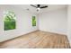 Empty bedroom featuring hardwood floors and two windows providing views of the lush backyard at 1847 Vinton St, Charlotte, NC 28216