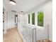 Upstairs hallway featuring hardwood floors, white railings, a window and an open doorway to the shower at 1847 Vinton St, Charlotte, NC 28216