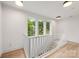 Upstairs hallway featuring modern white railings, hardwood floors, and bright windows overlooking the neighborhood at 1847 Vinton St, Charlotte, NC 28216