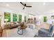 Open living space with hardwood floors, kitchen island seating, and a view to the outdoor deck at 1847 Vinton St, Charlotte, NC 28216
