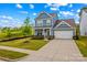Attractive two-story home with blue siding, a manicured lawn, and a double driveway in a walkable neighborhood at 194 Canada Dr, Statesville, NC 28677