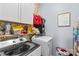 Practical laundry room with modern machines, white cabinets, and floral wallpaper at 194 Canada Dr, Statesville, NC 28677