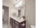 Bathroom featuring double sinks, dark cabinets, large mirror, and neutral walls, providing a clean and functional space at 2037 Christopher Wood Ct, Indian Land, SC 29707