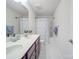 Bright bathroom offers a dual sink vanity with marble floors, shower and tub featuring a stylish patterned curtain at 2037 Christopher Wood Ct, Indian Land, SC 29707