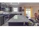 Open kitchen featuring a large island with seating, granite countertops, stainless steel appliances, and access to the deck at 2037 Christopher Wood Ct, Indian Land, SC 29707