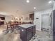 Open-concept kitchen with granite island and stainless appliances adjoins dining and living areas at 2037 Christopher Wood Ct, Indian Land, SC 29707